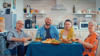 Aile ve hareketsiz büyükbaba bir video görüşmesi yapıyor.