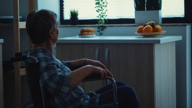 Üzgün, engelli, yaşlı bir kadın siluette.