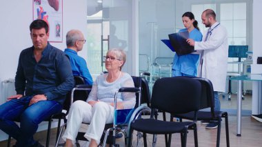 Hemşire doktorla konuşurken radyografiye bakıyor.