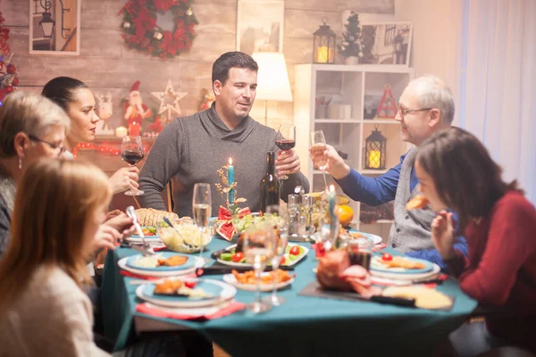 Happy senior man and his son clinking a glass of wine — Stock Photo, Image