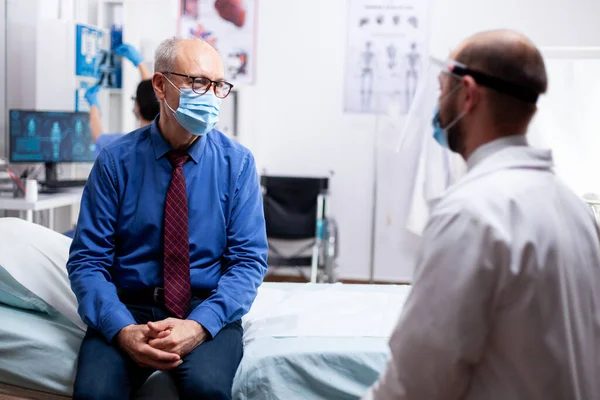 Sick old man listening doctor — Stock Photo, Image