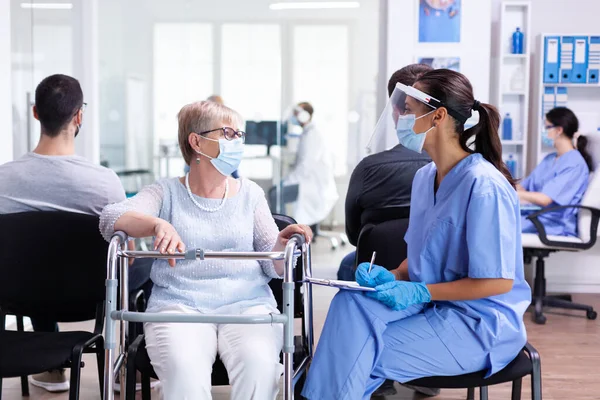 Behinderte Frau diskutiert mit medizinischem Personal — Stockfoto