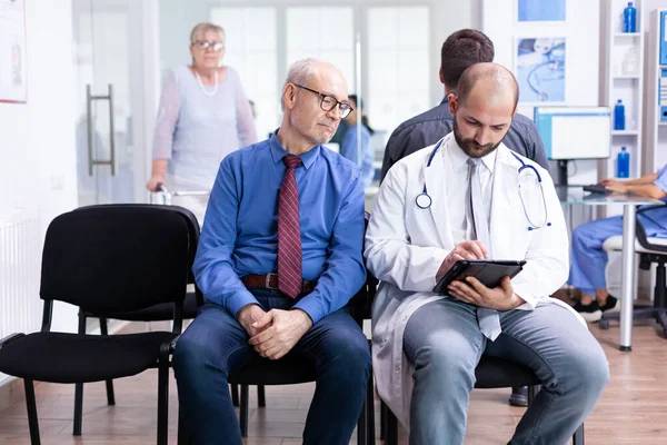 Oudere man luisteren arts diagnose — Stockfoto