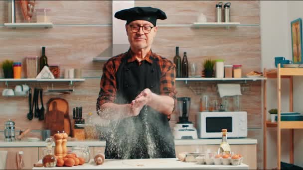 Am Küchentisch sitzen und mit Mehl in die Hände klatschen — Stockvideo