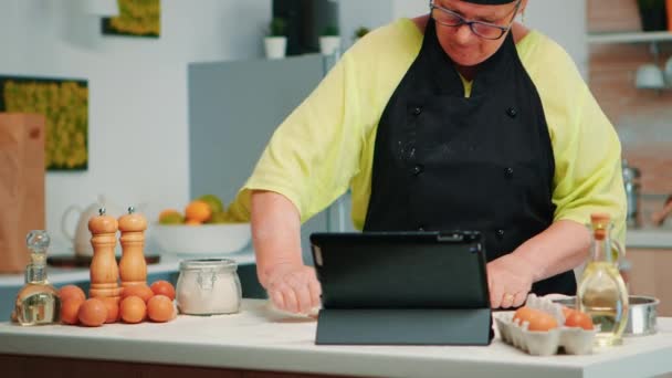 Aşçı kadın mutfakta tablet kullanıyor. — Stok video