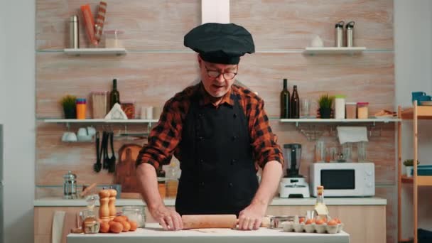 Reifer Mann bereitet Pizza am Küchentisch zu — Stockvideo