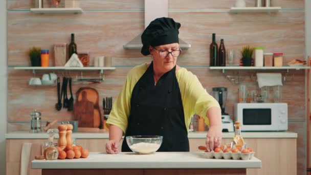Mujer panadero crujiendo huevos — Vídeo de stock