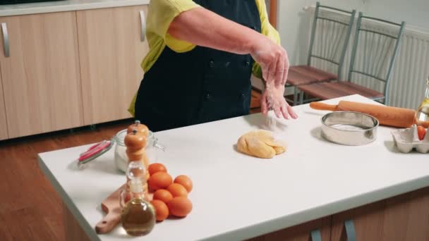 Emekli kadın ahşap masada yemek pişiriyor. — Stok video