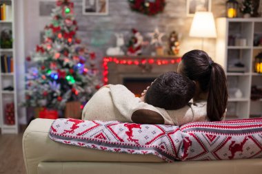 Genç adam başını kız arkadaşının omzuna yaslıyor.