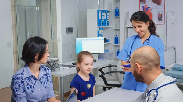Γιατρός και νοσοκόμα μιλούν με παιδί ασθενή — Φωτογραφία Αρχείου