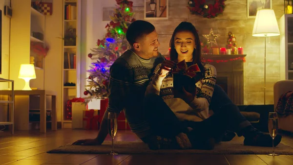 Belle jeune femme ouvre un cadeau miracle le jour de Noël — Photo