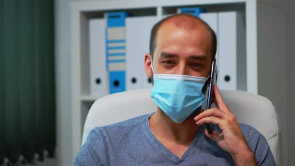 Portrét muže s maskou mluvící po telefonu — Stock video