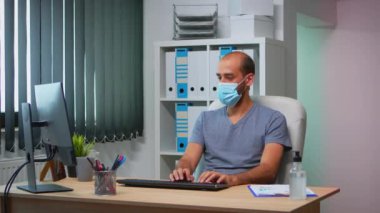 Yüz maskeli iş arkadaşları çalışıyor.