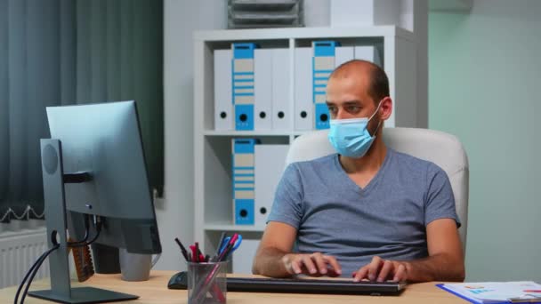 Gerente com máscara facial trabalhando no escritório — Vídeo de Stock