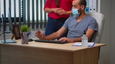 Yeni normal ofiste yüz maskesi takmak.