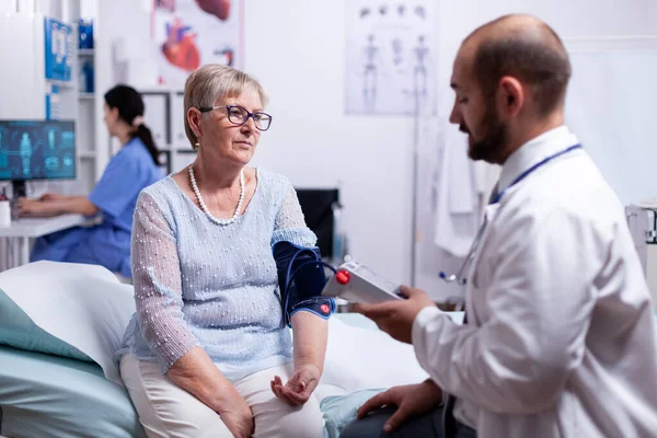 Arzt überprüft Blutdruck der Frau — Stockfoto