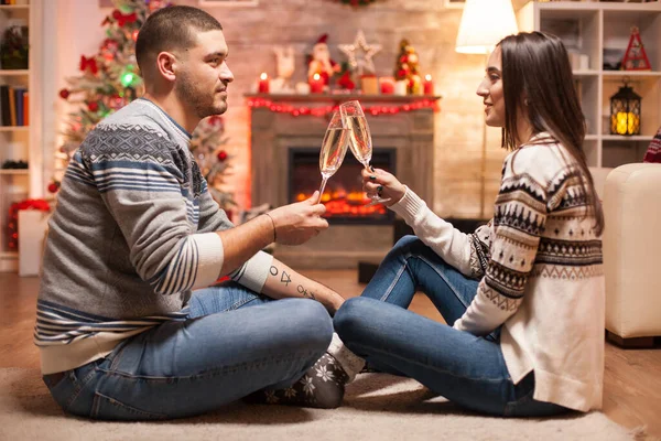 Romantic couple on christmas day in front of warm fireplace