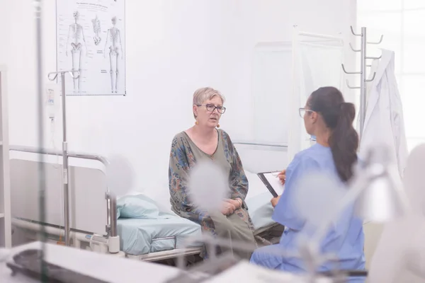 Verpleegster neemt notities tijdens overleg — Stockfoto