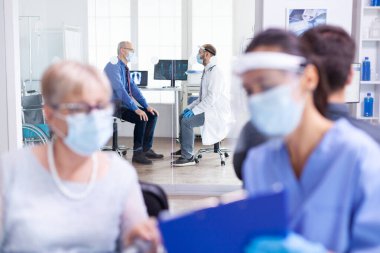 Yaşlı adam doktorla konuşuyor.