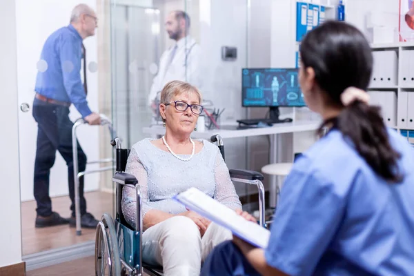 Gehandicapte vrouw luisteren verpleegster — Stockfoto