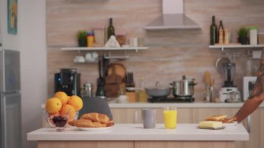 İç çamaşırlı kadın kahvaltı hazırlıyor.