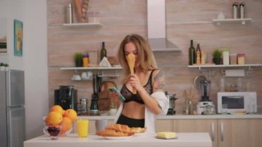 Kışkırtıcı kadın kaşıkta şarkı söylüyor.