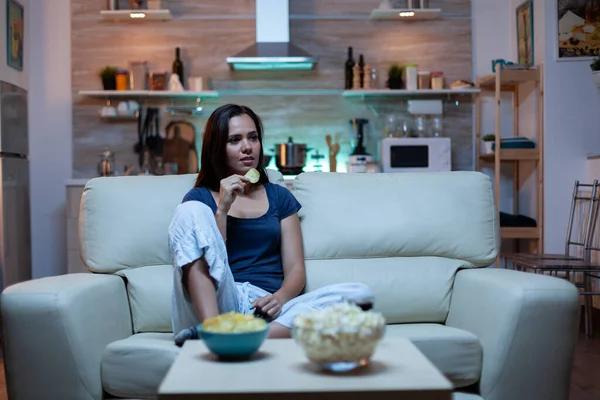 Ama de casa comiendo bocadillos en el sofá — Foto de Stock