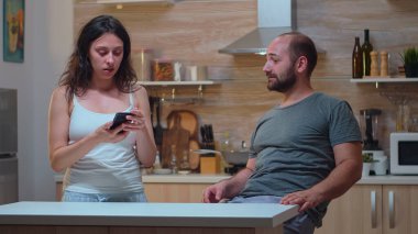 Kıskanç kadın, adamın telefonunu kontrol ediyor.