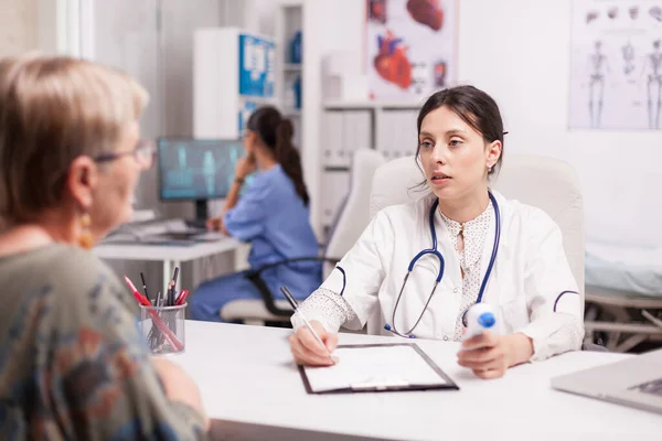 Ärztin betrachtet Seniorin — Stockfoto