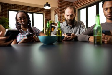 Akıllı telefonlar kullanan, abur cubur ve içeceklerle takılan bir grup yetişkin sosyal medyaya odaklandı. Cep telefonlarında gezinen ya da mesajlaşan arkadaş grubu.