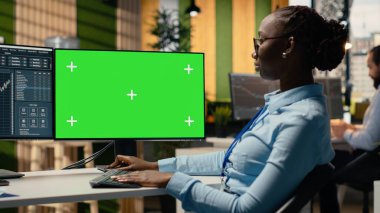 Portföy yöneticisi yeşil ekrandaki pazar eğilimlerini analiz ederek yatırım iadelerini artırıyor. Finansal uzman, yatırım olanaklarını belirlemek için model bilgisayardaki performans ölçümlerini izliyor