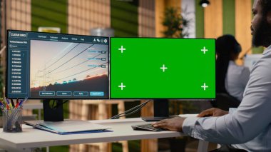 Mühendis, ofisteki izole ekran bilgisayarında güç hattı CAD tasarımı üzerinde çalışıyor. Ar-Ge uzmanı, iletim kulesi sistemlerini optimize etmek için bilgisayar üzerinde yazılım kullanır. Kamera B