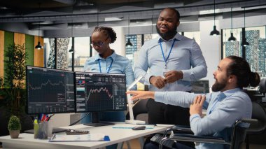 Parapleji ve aksesuar meslektaşı olan mutlu bir işçi başarılı ticaret operasyonlarından sonra beşlik çakıyor. Tekerlekli sandalyedeki neşeli tüccar ve iş arkadaşı portföy kârını kutluyor