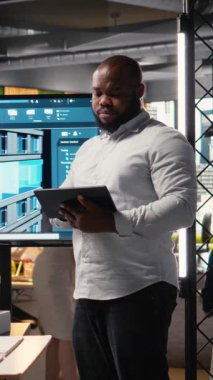 Vertical Video Afrikalı Amerikalı emlak müteahhidi şehir planlama planlarını dizüstü bilgisayarda gözden geçirir, sürdürülebilir konut kentsel gelişimi üzerine bir sunum hazırlarken altyapı hedefleri belirler