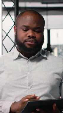 Dikey Video Emlak Yatırım Geliştiricisi, modern bir ofisteki inşaat alanının planlarını ve yerleşim planlarını kontrol ediyor. İkamet geliştirme projesi için imar yönetmelikleri analiz ediliyor