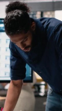 Vertical Video Ortadoğu emlak müteahhidi, altyapı büyümesi için kentsel konut projesi üzerinde çalışarak dizüstü bilgisayarın inşaat alanı planlarını değerlendiriyor. Akıllı şehir için yapısal tasarım