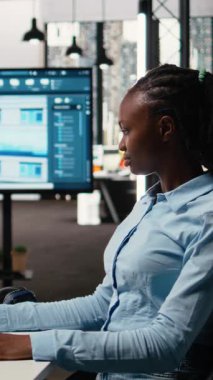 Dikey Video Siyah kadın uzmanı bir yazılımın iç tasarımı ve duvar yapısı üzerinde çalışarak emlak inşaatı projesi için bir düzen oluşturur. Kentsel gelişim için altyapı büyümesi