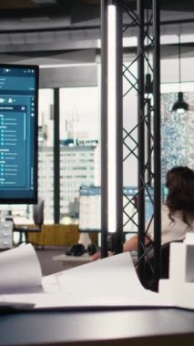 Dikey Video Siyah emlak mühendisi, taslak çizimi, imar düzenlemelerine ve diğer yerleşim planlarına uymak için planlama oturumunun detaylarını topluyor. Konut hazırlığı. Kamera.