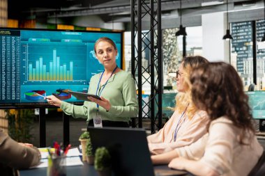 İş dünyasının rekabetçi sektöründe bir strateji oluşturmak için performans veri analizini kullanan ofis çalışanları takımı, verimli planlama yoluyla proje hedeflerini hızlandırmak için yetkilendirilmiş kadınlar.