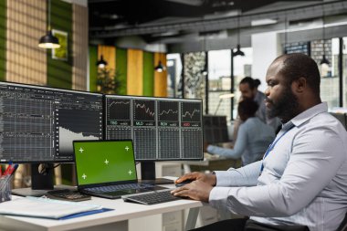 Borsa dalgalanmalarından faydalanmak için izole ekran bilgisayarı kullanan bir borsacı. Hızlı kar fırsatları için krom anahtar defterdeki fiyat hareketlerini analiz eden bir firma çalışanı