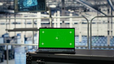 Yapay zeka destekli donanım destekli sunucu merkezinde yeşil ekran laptop. Veri merkezindeki yapay zeka operasyonları için geniş veri tabanlarını depolama ve işleme defterine kopyala