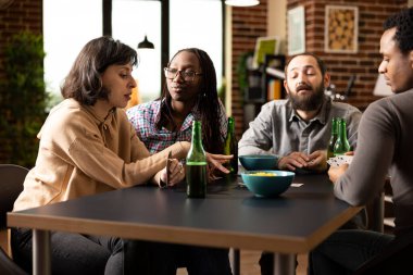 Bir grup arkadaş tuğla duvar dairesinde oturup kağıt oynuyorlar. Arkadaş canlısı atmosferle masada takılırken çok ırklı insanlar konuşuyor, bira ve abur cubur yiyor..