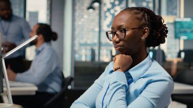 Borsa çöktükten sonra simsar, yatırım portföyü şamdan grafiklerine bakarken kaşlarını çatmış. Afro-Amerikalı kadın borsa kayıpları yüzünden üzgün.