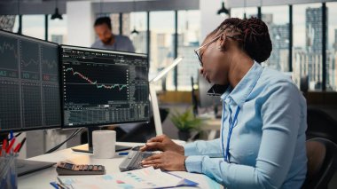 Ofisteki öz sermaye analisti üç aylık kazanç belgelerini gözden geçirip gelecekteki borsa değerini belirlemek için telefonda konuşuyor. Tüccarlar yatırımları iyileştirmek için telefon açar, finansal analiz yapar.