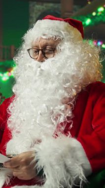 Dost canlısı Noel Baba 'nın dikey video portresi. Tatil sezonunda Noel neşesi yayma, ailelerle yakınlaşma tutkusu. Noel Baba gibi giyinmiş bir adam Neşeli yaratıyor