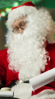 Dikey Noel Baba telefonlara cevap veriyor, hediye isteyen çocuklara cevap veriyor. Noel Baba 'yı taklit eden kişi çocuklarla Noel hediyeleri hakkında konuşuyor sabit telefon ve kamera A' yı kullanıyor.