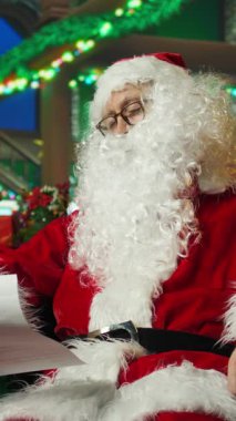 Noel Baba kılığındaki dikey videocu çocuk yardım etkinliğinden sonra yorgun düşmüş bir şekilde koltukta uyuyor. Sahte sakal kestiriyor, çocukları ziyaret ettikten sonra yorgun, kamera önünde.