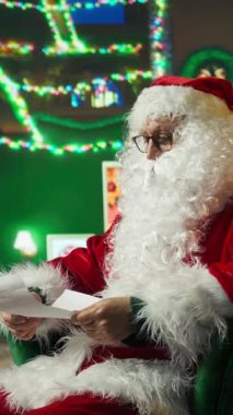 Dikey Noel Baba başını sallayarak çocuklardan gelen mektuplara karşı çıkıyor. Noel kostümü giyen kişi çocukların yazdığı istek listelerini okur pahalı hediyeler ister, onaylamayan kafa yapar.