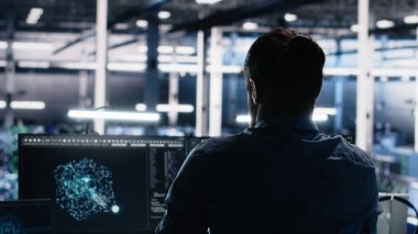 Sunucu odası teknisyeni masasında yapay zeka kullanırken sırtını geriyor. Veri merkezindeki yorgun bilişim uzmanı gergin kasları gevşetiyor, yapay zeka kullanırken sırt ağrısı çekiyor, kamera A