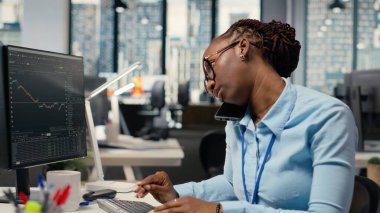 Ofisteki öz sermaye analisti üç aylık kazanç belgelerini gözden geçirip gelecekteki borsa değerini belirlemek için telefonda konuşuyor. Tüccarlar yatırımları iyileştirmek için telefon açar, finansal analiz yapar.